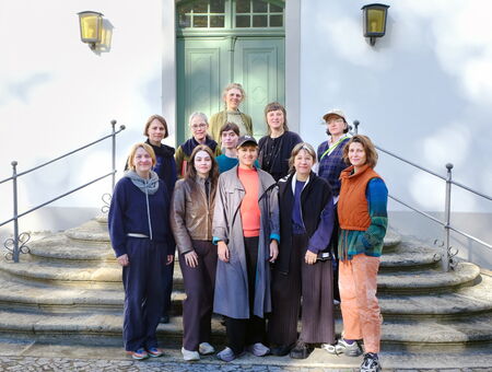 The group members are standing on a staircase in front of the entrance door at Wiepersdorf.