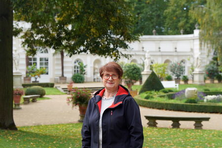 Roswitha Karbaum mit dem Park und der Orangerie von Schloss Wiepersdorf im Hintergrund