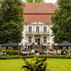 Eine Totalansicht von Schloss Wiepersdorf mit Publikum vor der Schlossterrasse