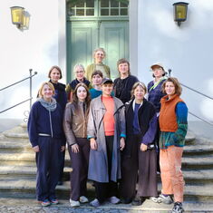 Die Gruppenteilnehmer:innen stehen in Schloss Wiepersdorf vor der Eingangstür auf einer Treppe.