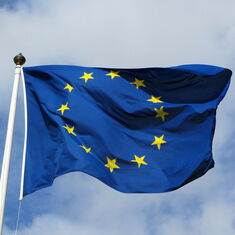 Die EU-Flagge weht im Wind, dahinter ein blauer Himmel