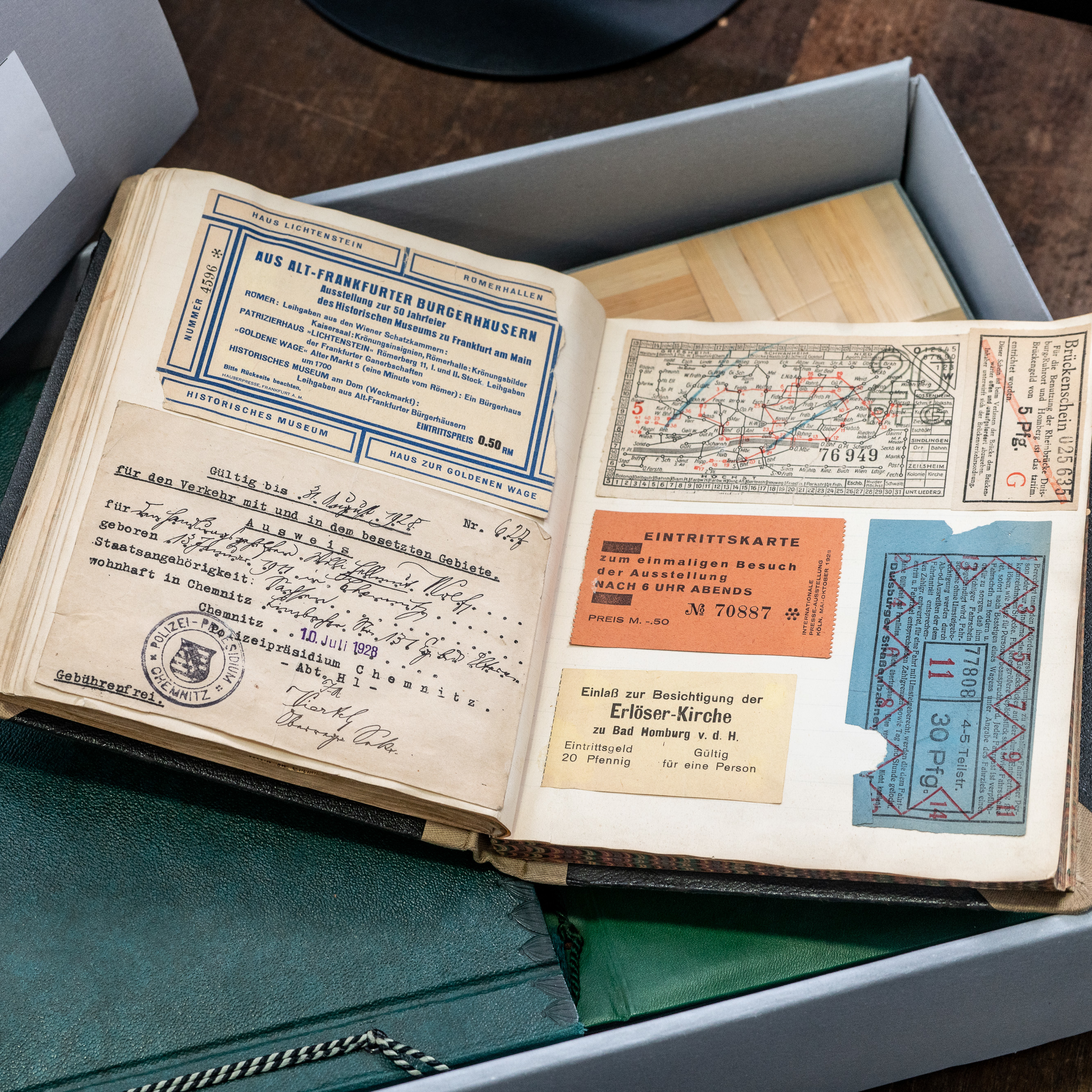 Ein aufgeklapptes Buch, das Eintrittskarten und anderes Archivmaterial zeigt